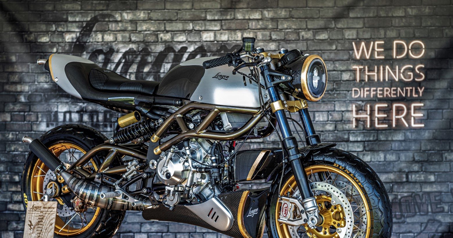 Langen Two Stroke in front of the We Do Things Differently Here wall